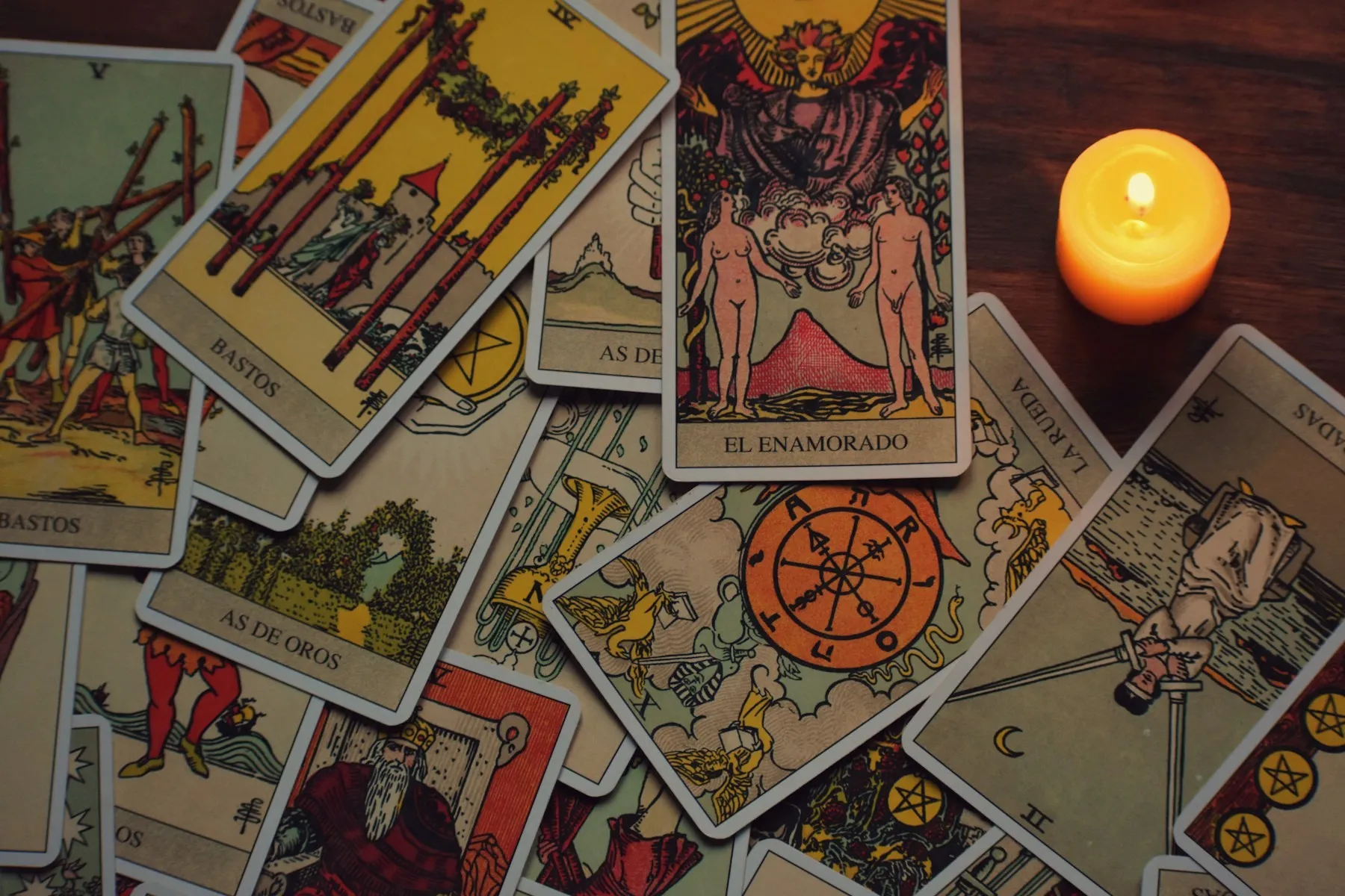 A spread of tarot cards with a burning tealight
